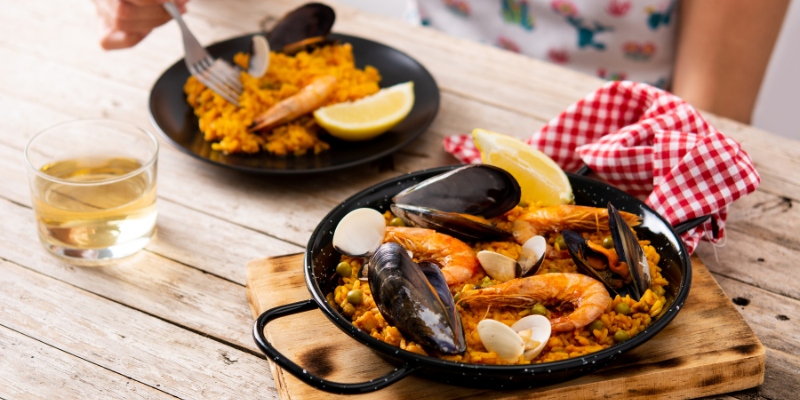 Pan with seafood on a table with rice.